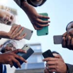 Shot of a group of businesspeople using phones outside