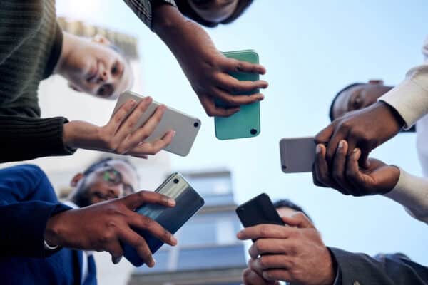 Shot of a group of businesspeople using phones outside
