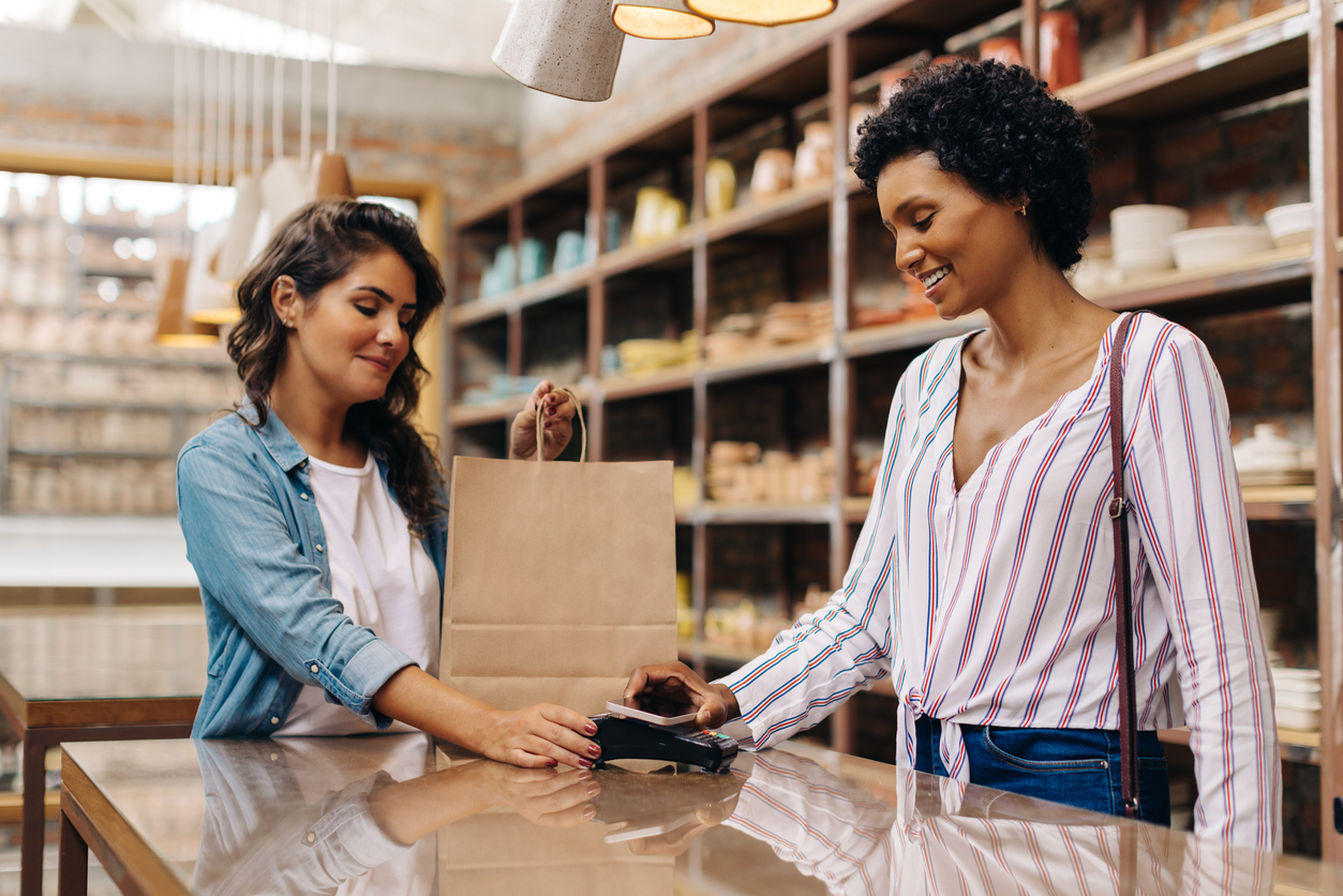 Female customer making an NFC payment in a ceramic store