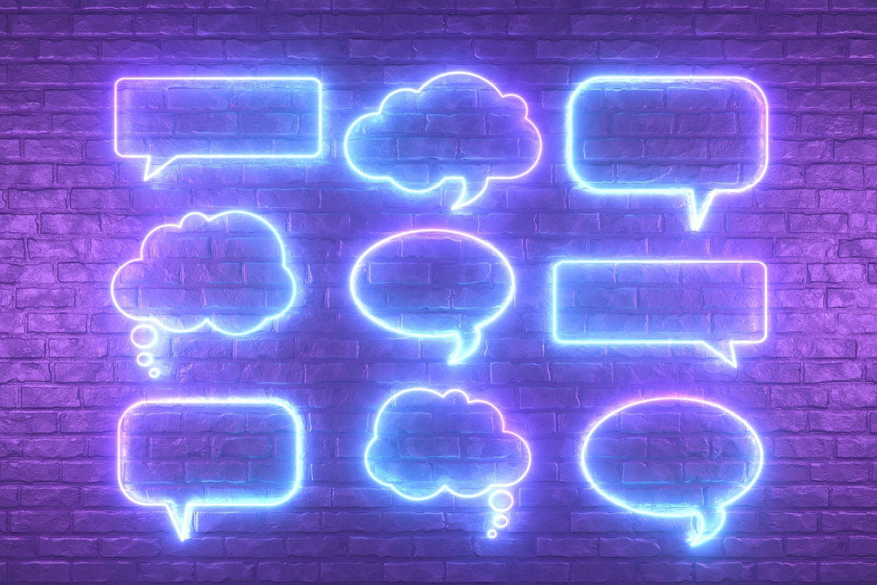 Neon Lighting Glowing Speech Bubble on Black Brick Wall