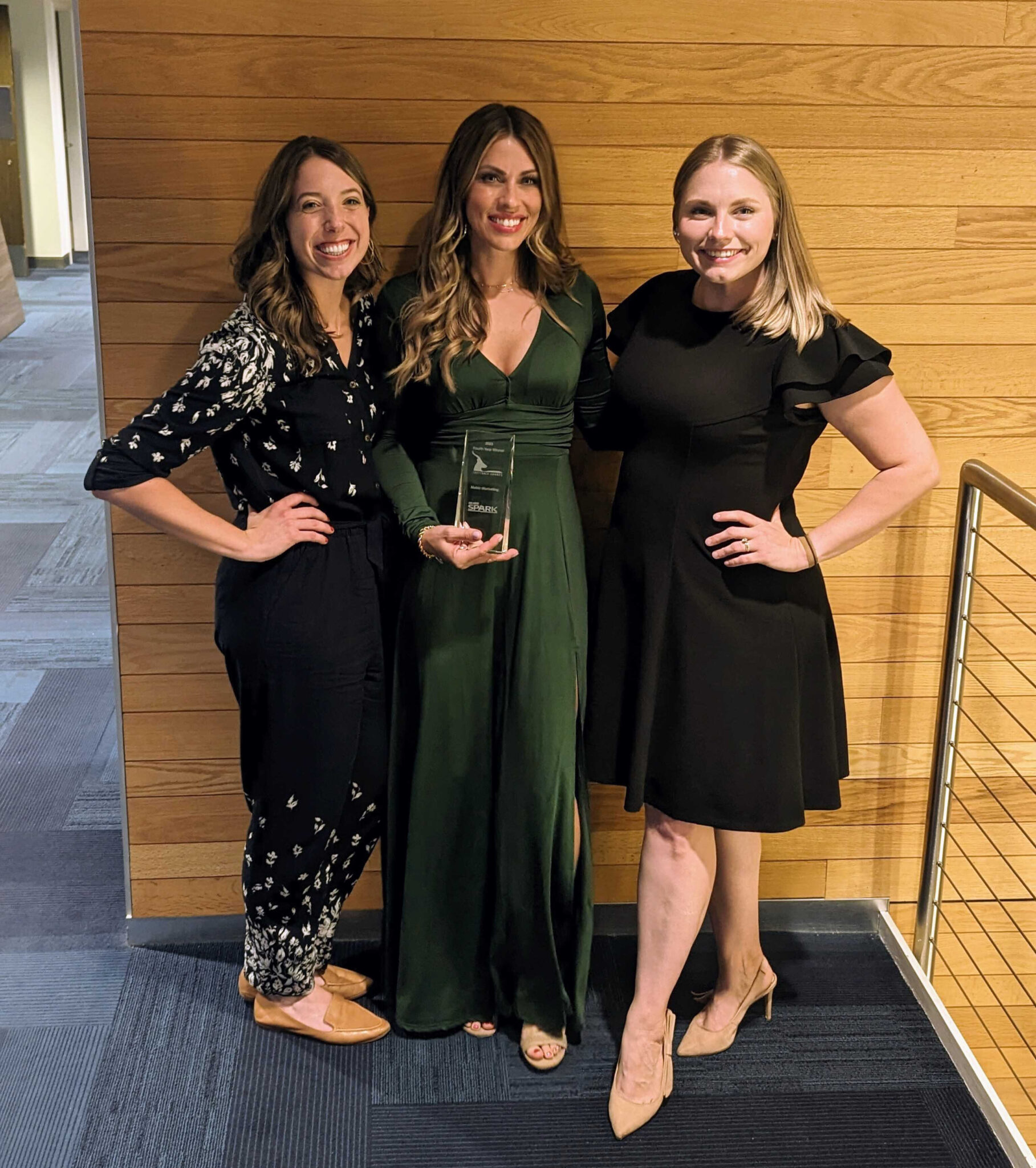 Alex, Hannah, and Paige of the Metric Marketing Team Holding a FastTrack Award From Ann Arbor SPARK